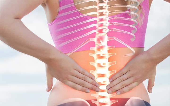 woman holding back needing to have her spine aligned