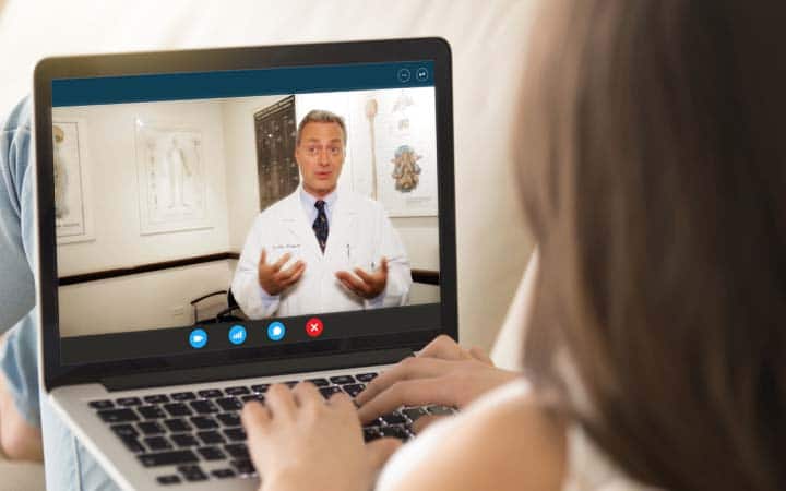 alex eingorn is seen on a laptop furing a tele video consultation